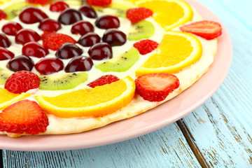 Homemade sweet pizza with fruits on wooden table, close up