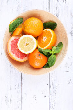 Fresh Citrus Fruits With Green Leaves In Bowl