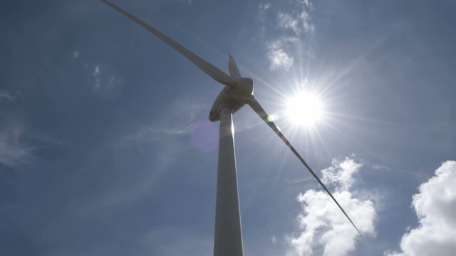 Windrad mit Sonne im Hintergrund