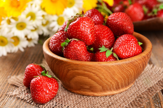 Ripe sweet strawberries in bowl on table close-up