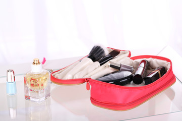 Cosmetic bag on table on light background