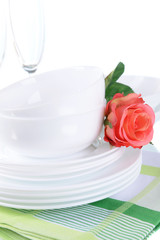 Set of white dishes on table on light background
