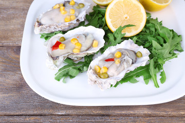 Tasty cooked oysters in shell on wooden table