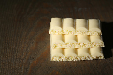 White chocolate bar on color wooden background