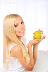 Young beautiful woman with apple on couch