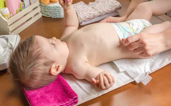 Mother Changing Diaper Of Adorable Baby