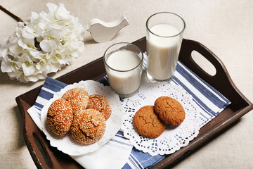Milk and cookies on tray on table