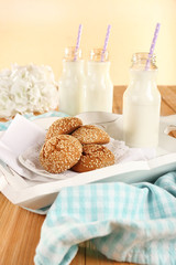 Milk and cookies on tray on table