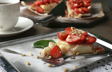Piece of strawberry tart on  tray, on rustic wooden background