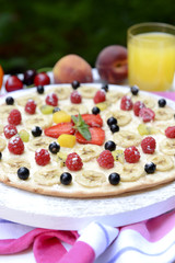 Sweet pizza with fruits on table close-up