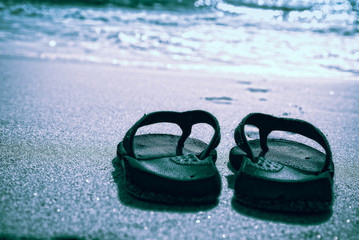 Flip flops on a sand beach