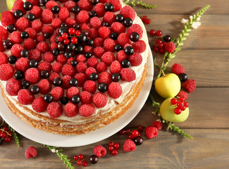 Tasty cake with fresh berries on wooden table