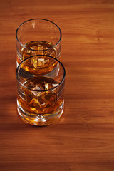 Highball whiskey glass with ice and lemon.