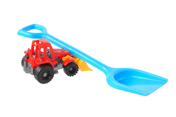 Two plastic toys. Shovel and tractor.