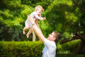 Happy family, dad and little son having fun  in the sand outdoor