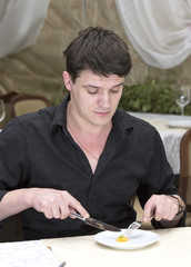 young man having dinner in a restaurant