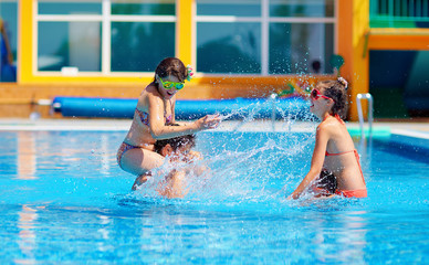 excited friends having fun in pool, water fight