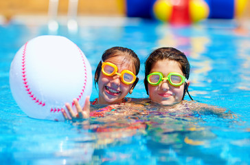 teenage friends playing with ball in the pool