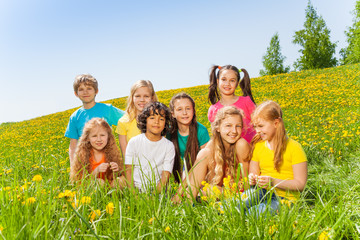 Funny children sitting together on green grass