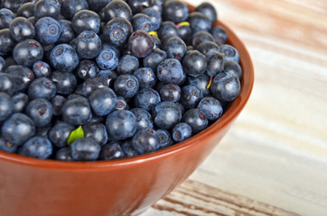 Blueberry in bowl on vintage wooden background