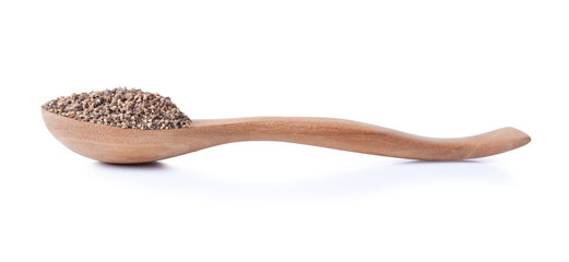heap of powdered black pepper on a wooden spoon