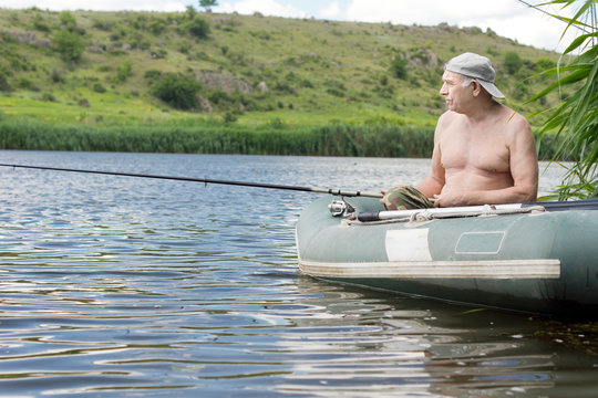 Senior man relaxing fishing from a dinghy