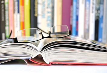 Offenes Buch mit Bücherreihe im Hintergrund