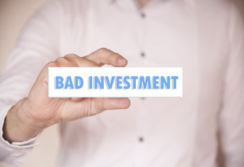 Man holding a word: Bad investment