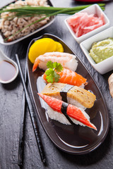 Delicious sushi pieces served on black stone