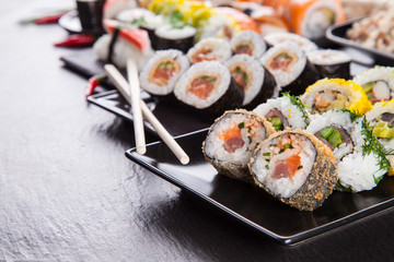 Delicious sushi pieces served on black stone