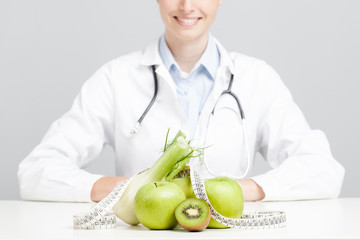 Nutritionist female Doctor in her office. Focus on fruit - 66654235