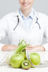 Nutritionist female Doctor in her office. Focus on fruit - 66654282