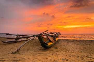 Traditionelles Auslegerboot bei Sonnenuntergang am Strand
