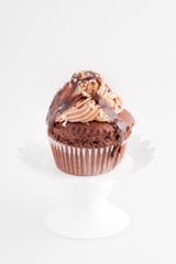 Cupcake al cioccolato su un'alzatina isolato su sfondo bianco