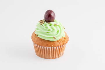Cupcake verde con ciliegina  isolato su sfondo bianco