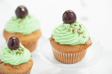 Cupcake verdi con ciliegina  isolati su sfondo bianco