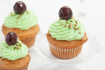 Cupcake verdi con ciliegina  isolati su sfondo bianco