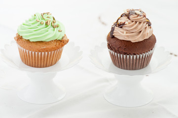 Due cupcake  su alzatine isolati su sfondo bianco