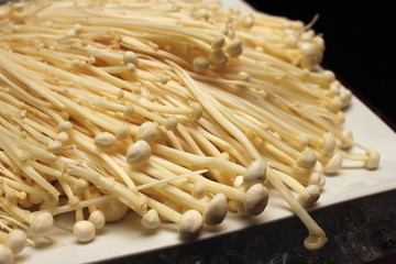 enoki mushrooms isolated against a white background.
