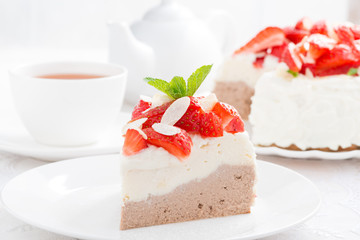 piece of cake with whipped cream, fresh strawberries and tea