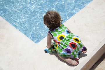 Niña pequeña en el borde de una piscina