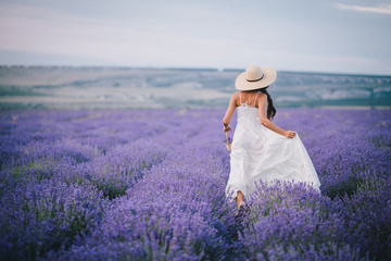 Beautiful young woman running in a lavender field