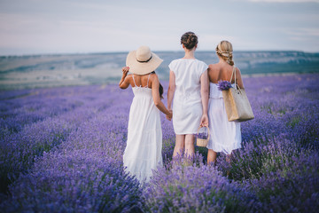 Three women posing in a lavender field