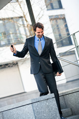 Smiling businessman walking down stairs