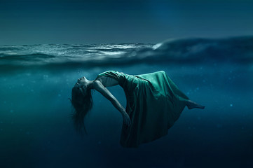 Woman floating underwater - obrazy, fototapety, plakaty