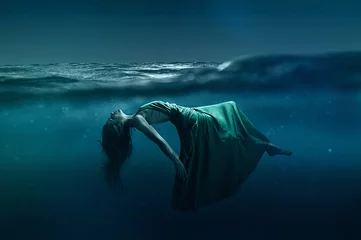 Frau, die unter Wasser schwimmt © lassedesignen