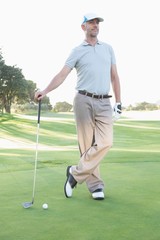 Obraz premium Handsome golfer standing with club