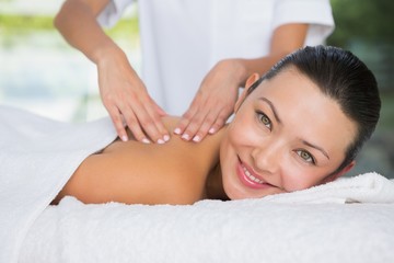 Obraz na płótnie Canvas Content brunette getting a back massage smiling at camera