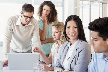 Casual businesswoman smiling at camera during meeting