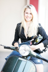 Fototapeta na wymiar hübsche Frau sitzt auf einem Motorroller